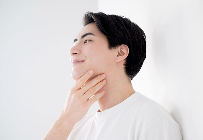 アゴをさわる男性